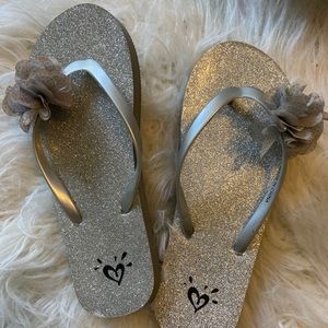 Flip flops with a flower on the toe strip